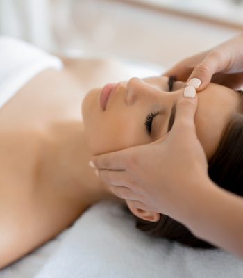 Calm girl having spa facial massage in luxurious beauty salon